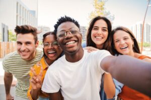 A group of smiling teenagers of different races taking a selfie.
