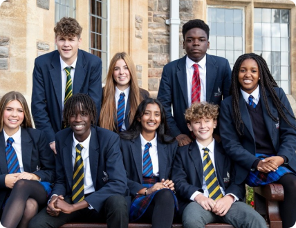 Eight students sitting and smiling while posing for a picture